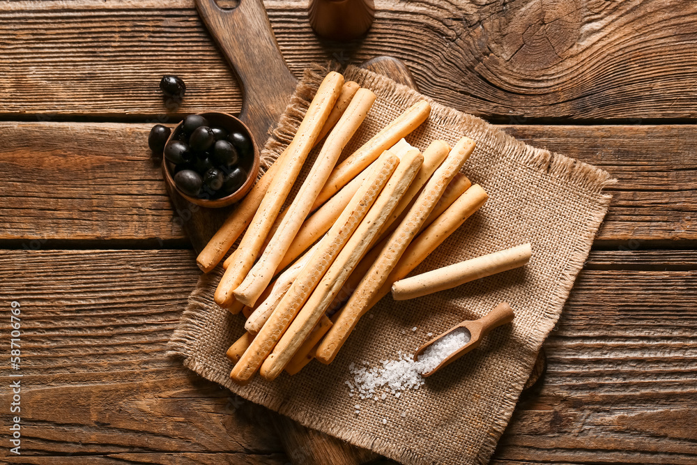 Board with tasty Italian Grissini on wooden background