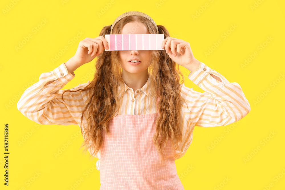 Female artist with paint color palette on yellow background