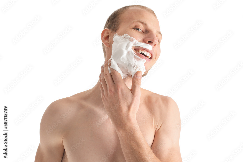 Young man applying shaving foam onto face against white background