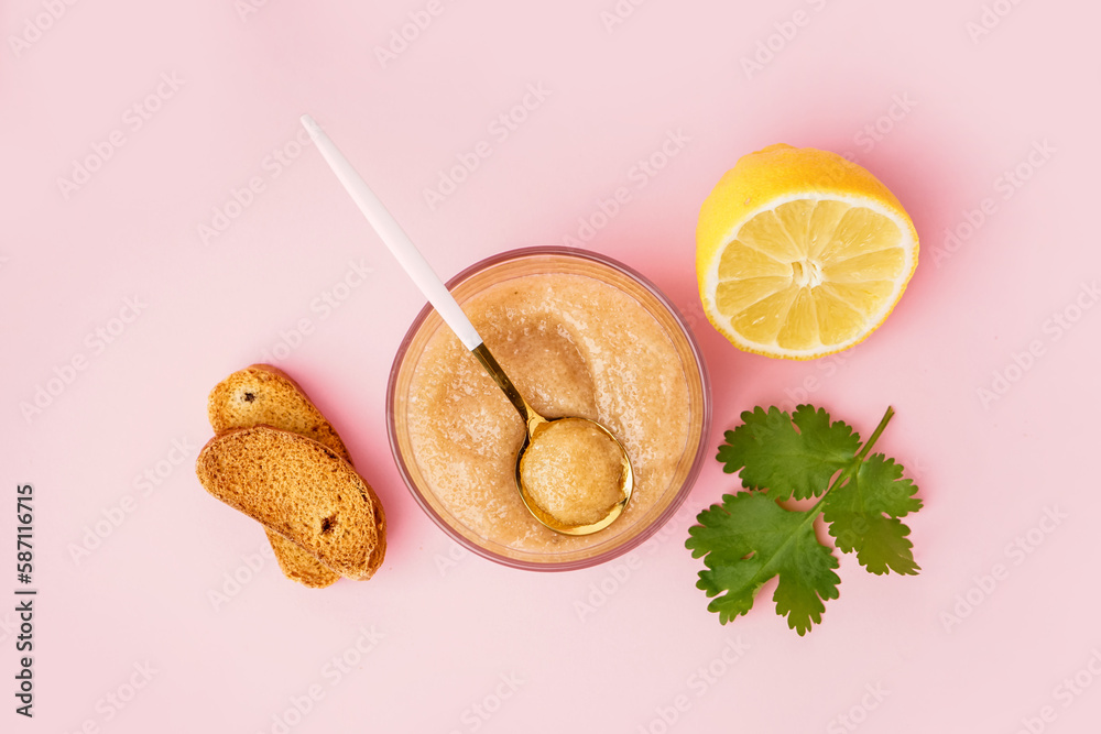 Glass with delicious caviar of capelin and croutons on pink background