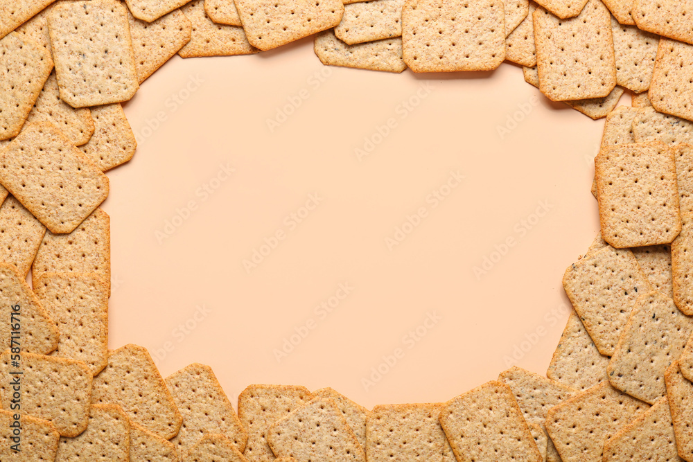 Frame made of tasty crackers on beige background