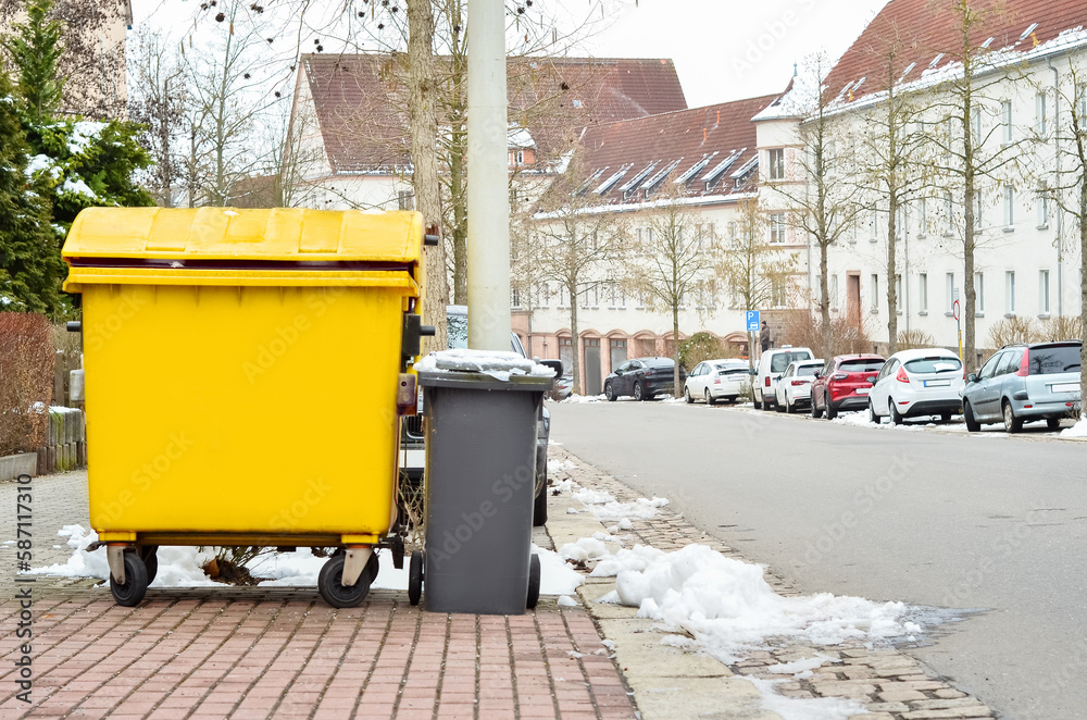 View of garbage containers in city on winter day