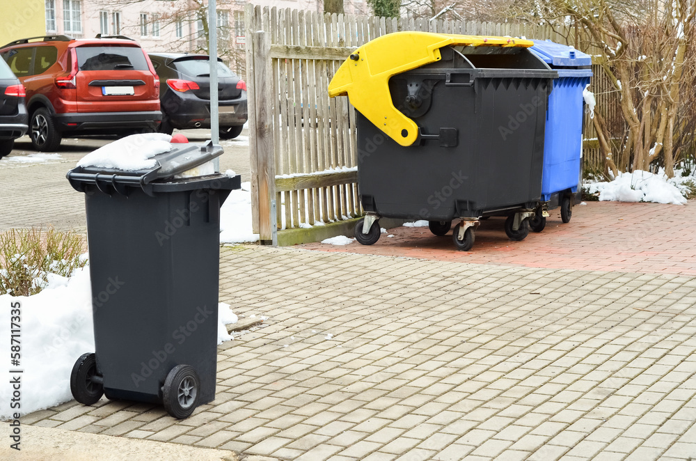 View of garbage containers in city on winter day