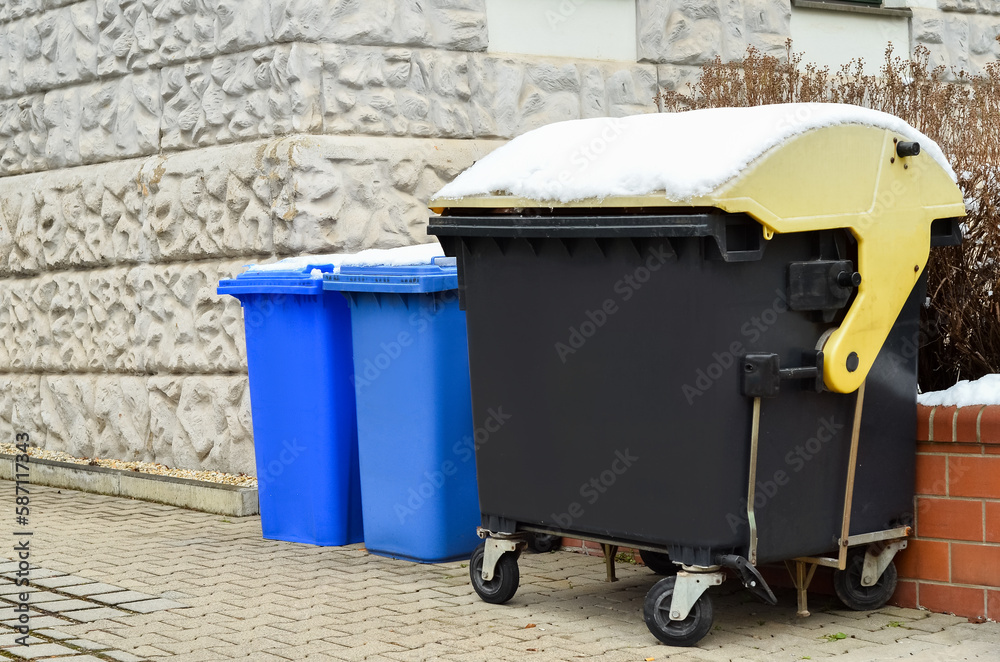 View of garbage containers in city on winter day