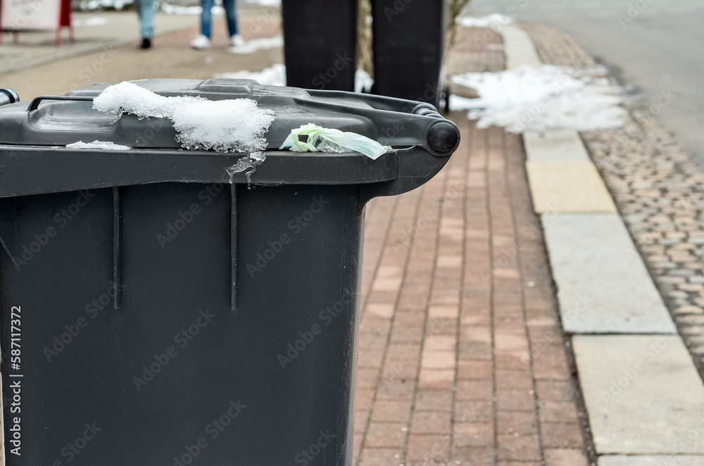 View of garbage container in city on winter day, closeup