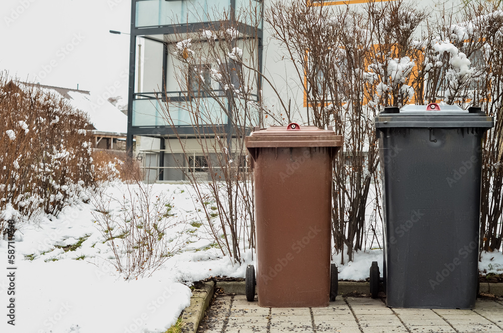 View of garbage containers in city on winter day