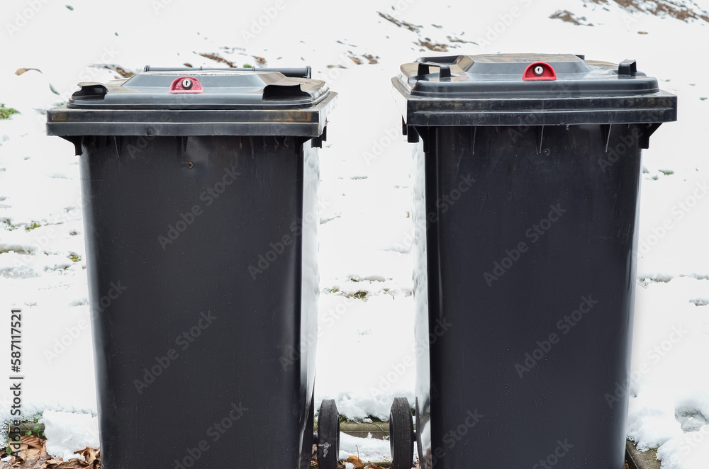 View of garbage containers in city on winter day