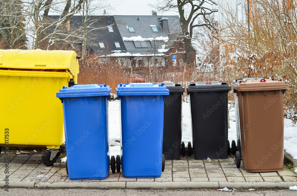 View of garbage containers in city on winter day