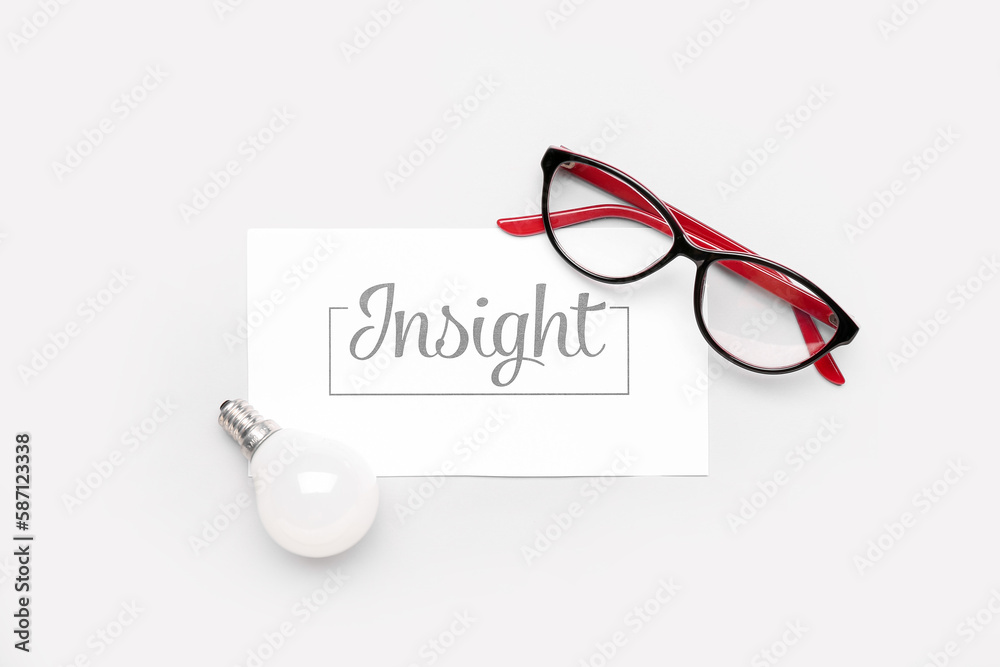 Paper with word INSIGHT, eyeglasses and light bulb on light background