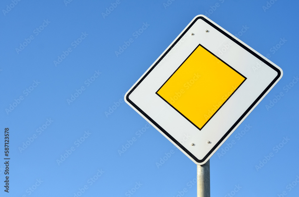 Main road sign against blue sky, closeup