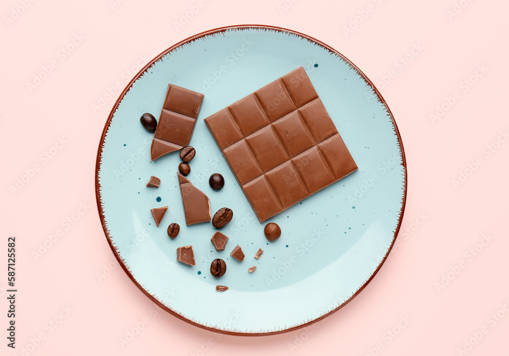 Plate with pieces of tasty chocolate and coffee beans on color background