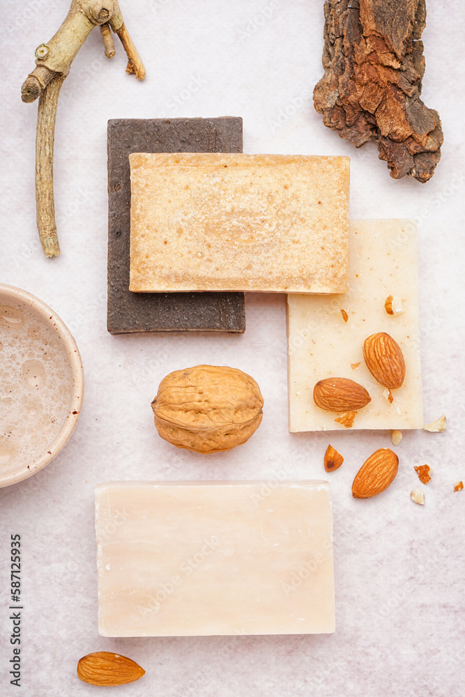 Composition with natural soap bars and nuts on light background