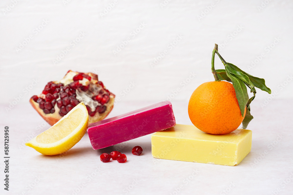 Natural soap bars and fruits on light background