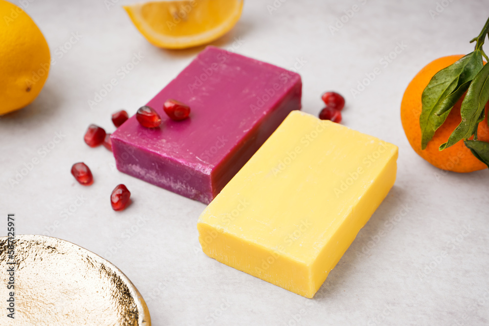 Natural soap bars and fruits on light background