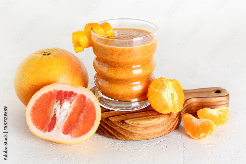 Glass of healthy smoothie and ingredients on light background