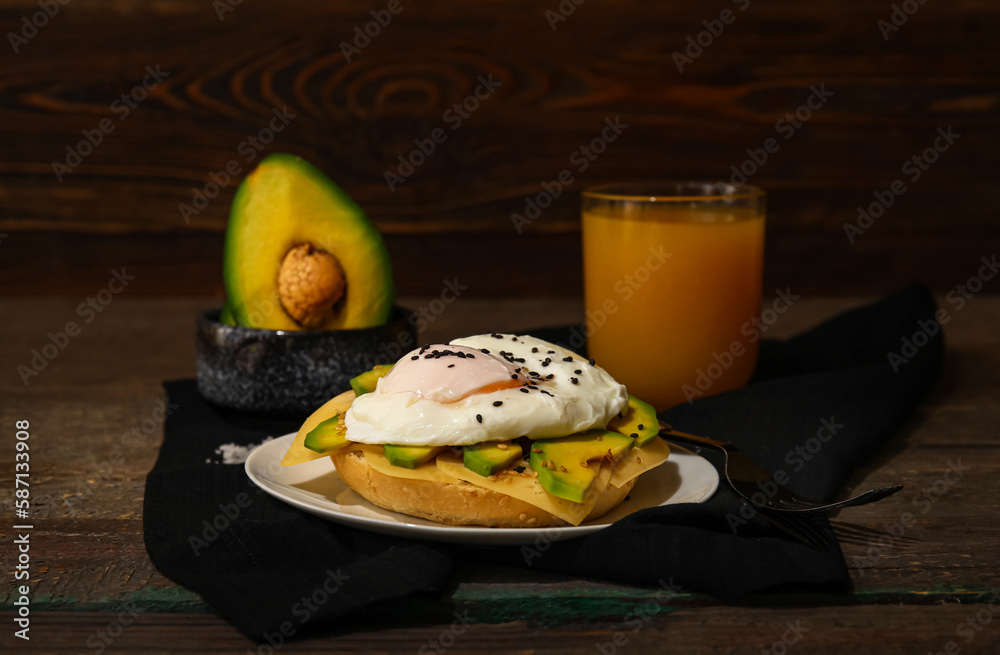 Plate with tasty egg Benedict and glass of juice on wooden background