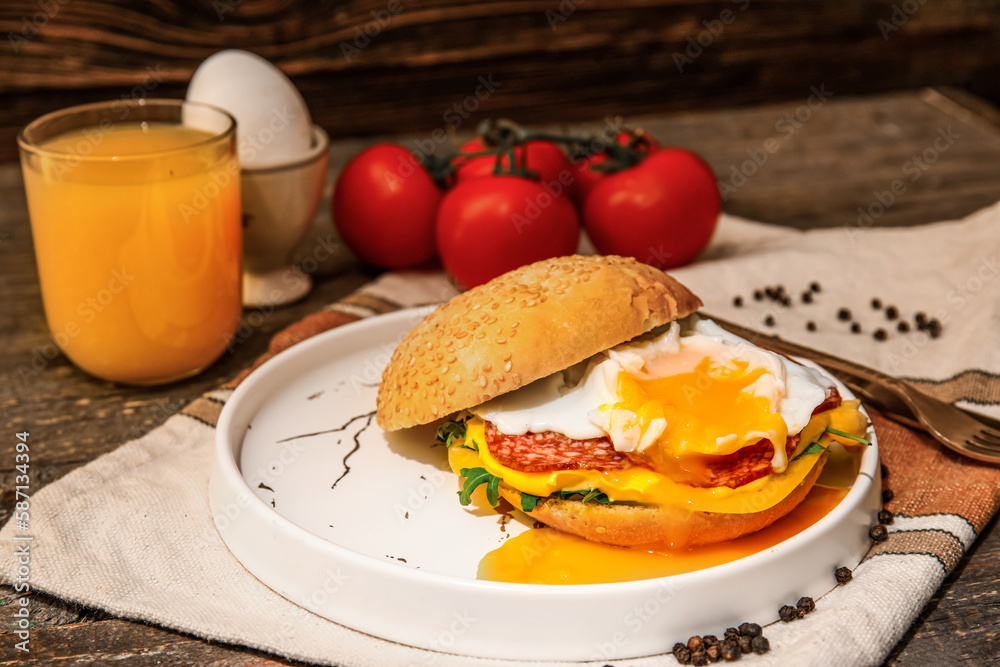 Plate with tasty egg Benedict and glass of orange juice on wooden background