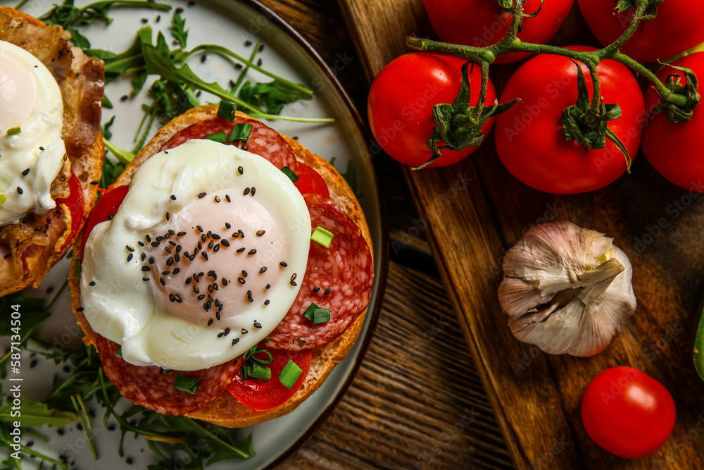 Plate with tasty eggs Benedict and tomatoes on wooden background, closeup