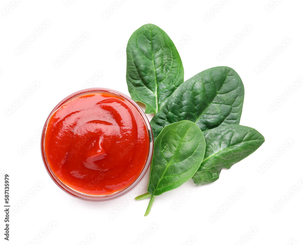 Bowl of tasty ketchup and spinach leaves isolated on white background