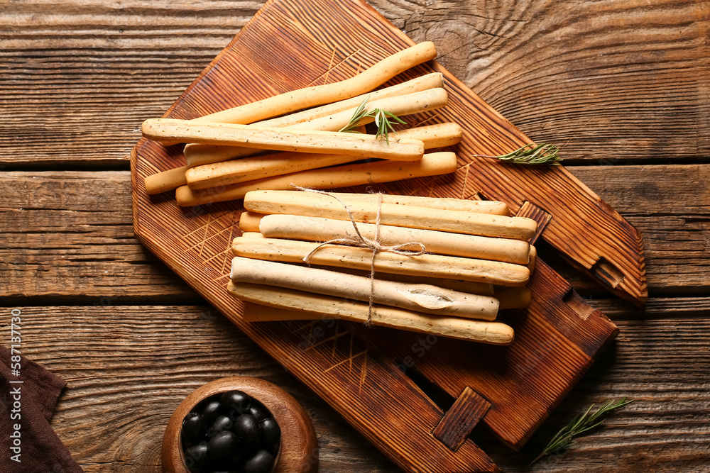 Board with tasty Italian Grissini on wooden background