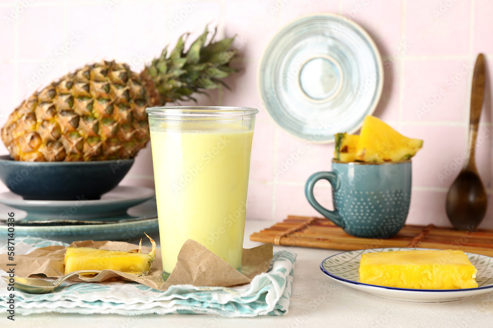 Glass of tasty pineapple smoothie on table in kitchen