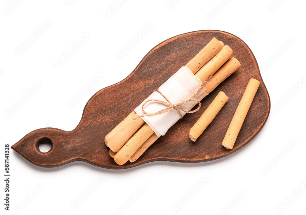 Wooden board with bunch of tasty Italian Grissini on white background