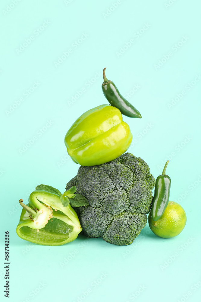 Composition with different fresh green vegetables on color background