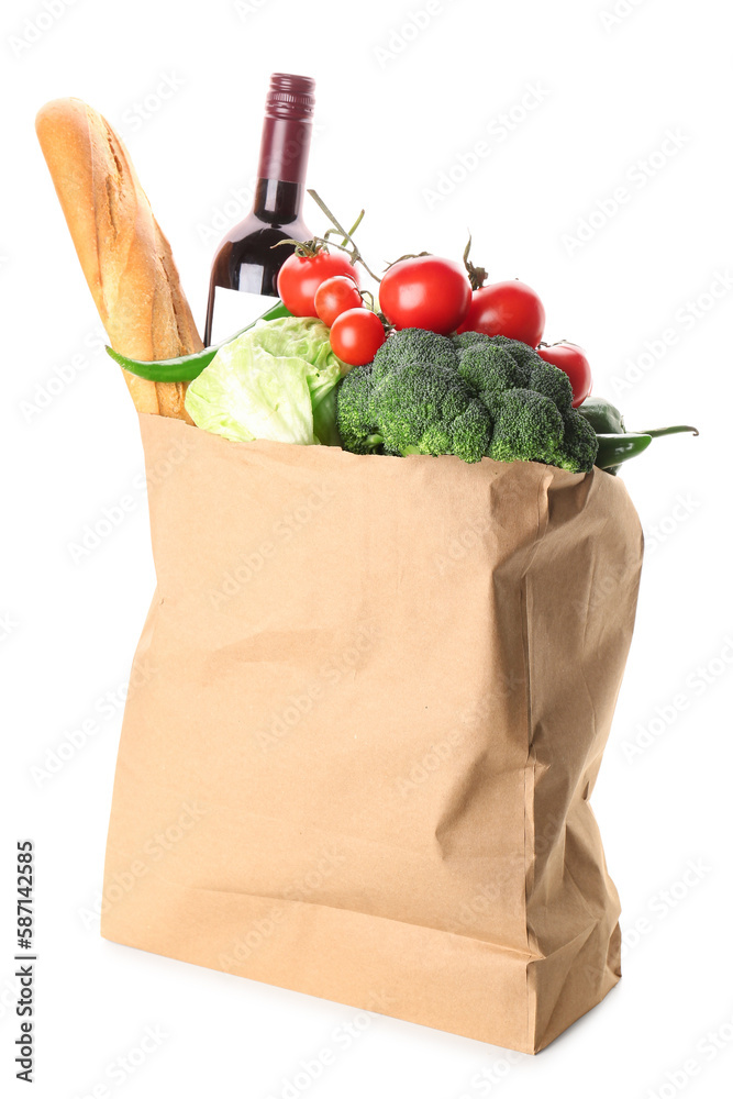 Paper bag with vegetables, bread and wine bottle on white background