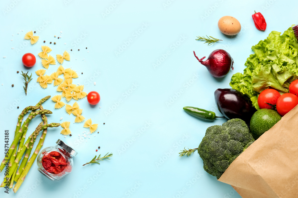 Paper bag with vegetables on light blue background