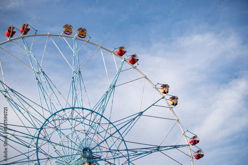 Ferris wheel, booths against the blue sky.