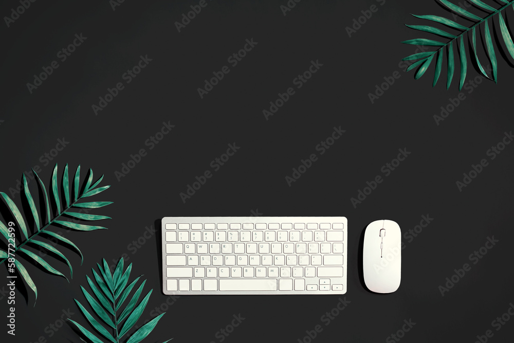 Computer keyboard and mouse with tropical leaves