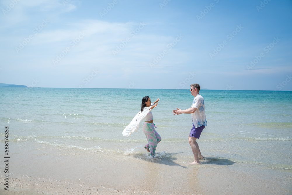 Happy young beautiful couple man and woman on the beach,Fun,Holiday.