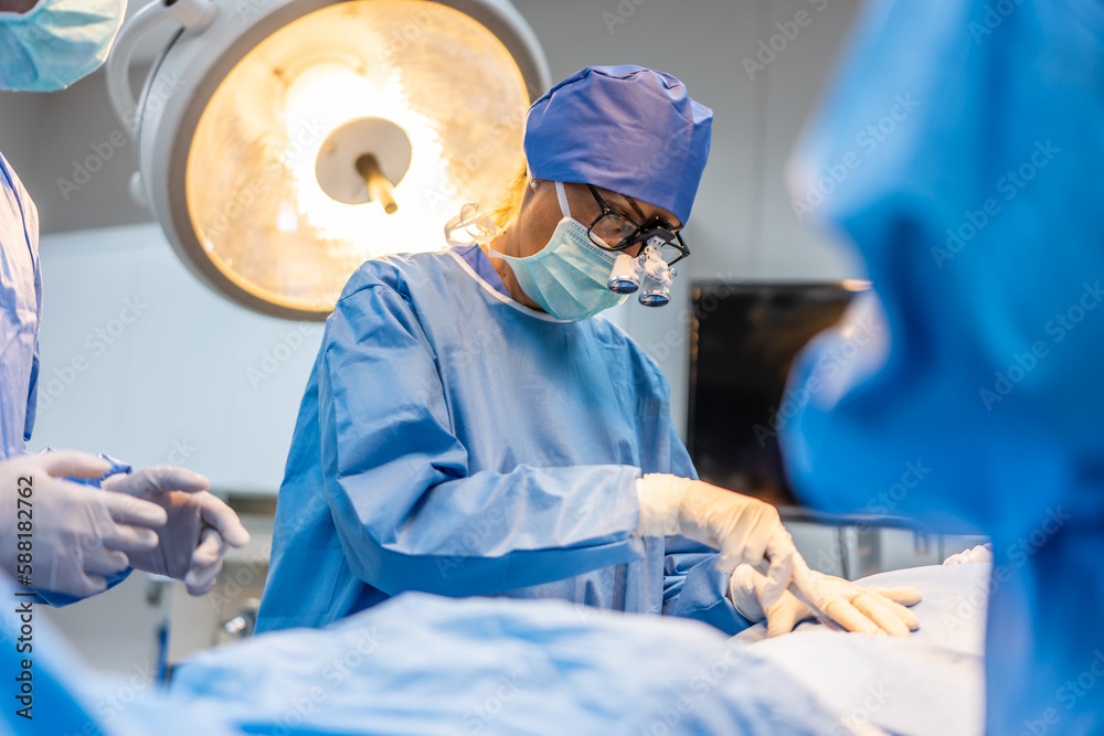 Professional doctors performing surgical operation in operating room.