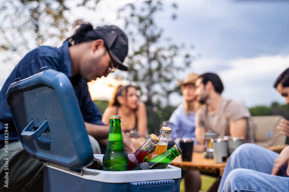 Group of diverse friend having outdoors camping party together in tent. 