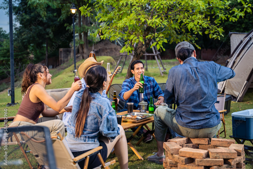 Group of diverse friend having outdoors camping party together in tent. 