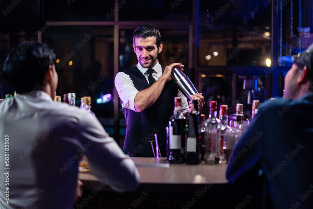 Caucasian profession bartender making a cocktail for women at a bar. 