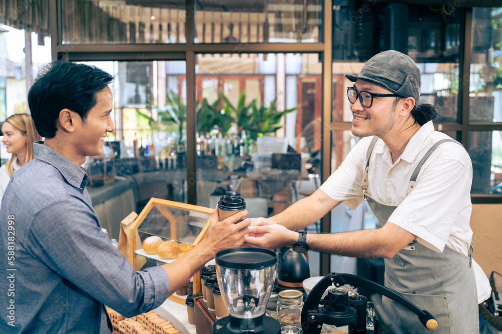 Asian attractive men receive hot coffee from waiter in coffee house. 