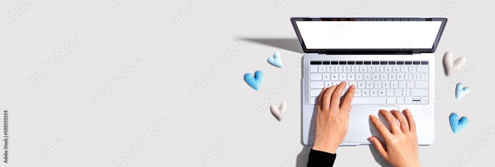 Laptop computer with heart cushions - flat lay