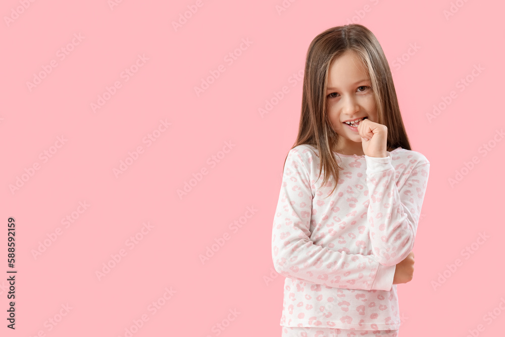 Little girl biting nails on pink background