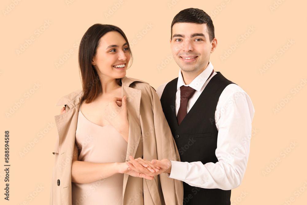 Elegant young couple on beige background