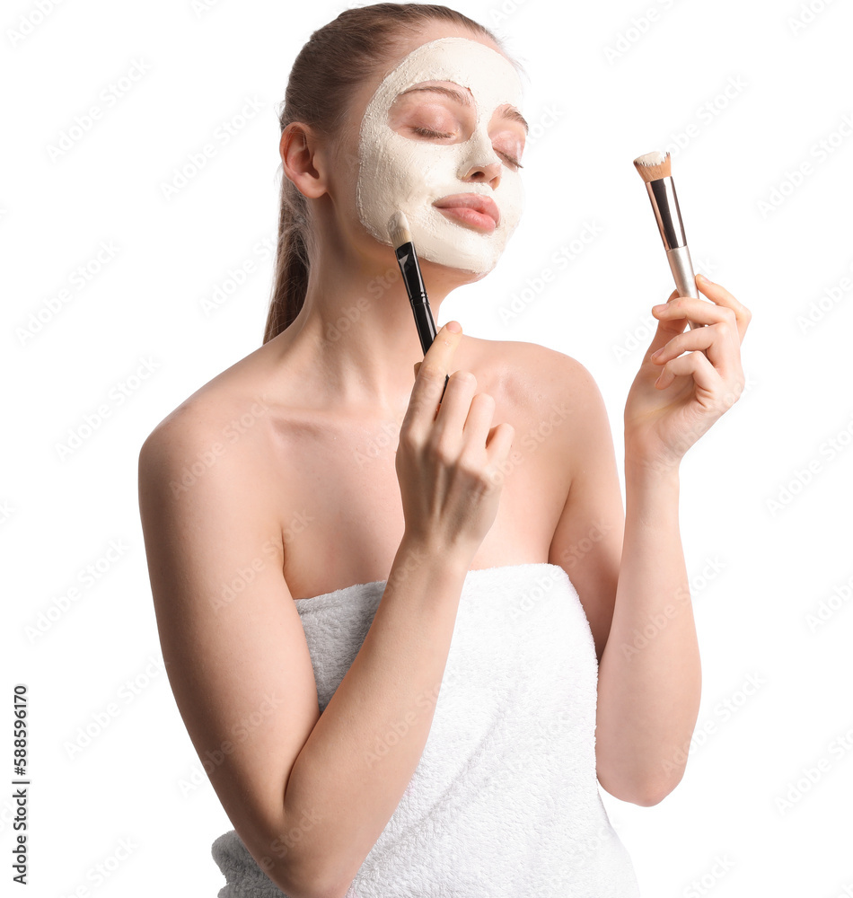 Young woman with applied turmeric mask and brushes on white background