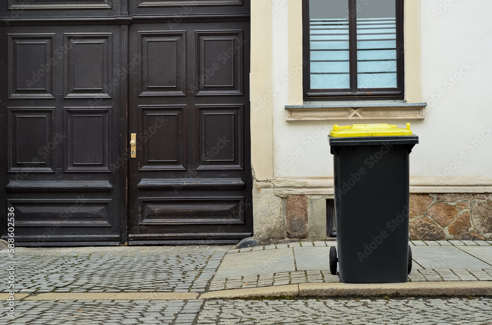 View of garbage container near old building in city