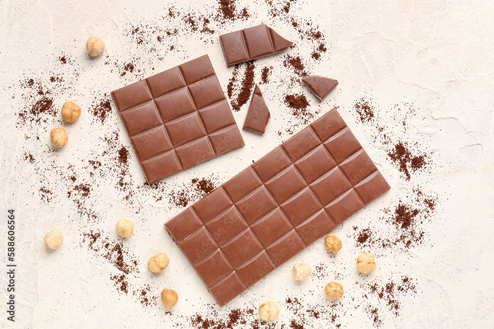 Composition with tasty chocolate, hazelnuts and coffee powder on light background