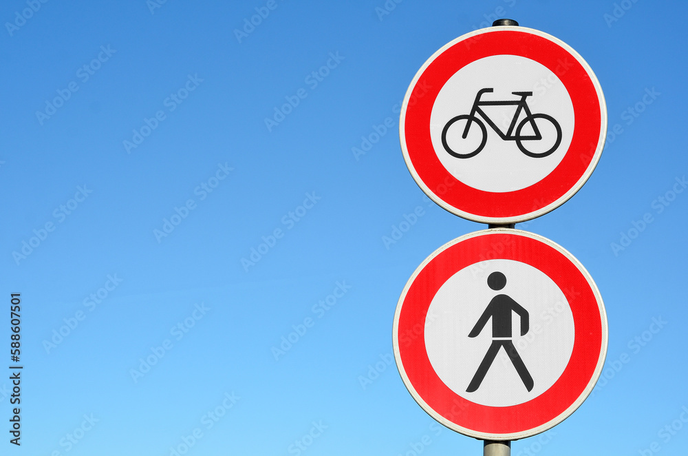 Cyclists and pedestrians prohibition signs against blue sky