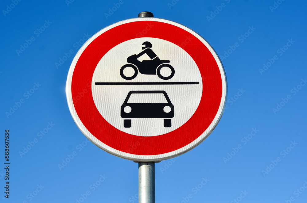 Motorcycles and cars prohibition sign against blue sky, closeup