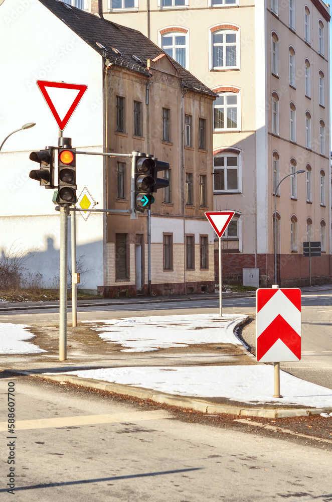 View of road with traffic lights and signs on winter day