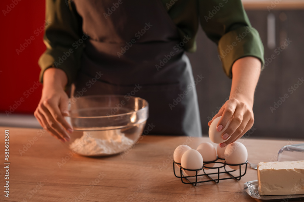 Woman making dough for pasta at table in kitchen, closeup