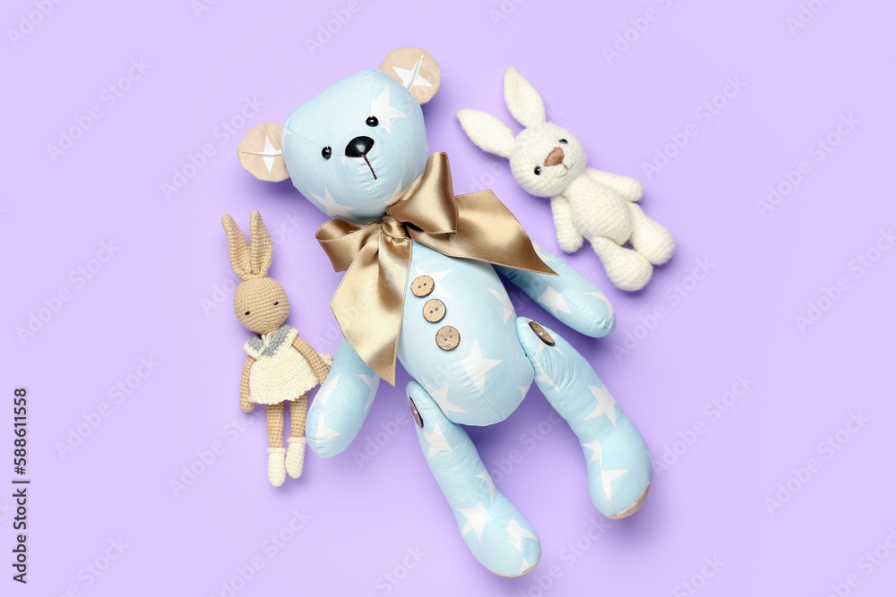 Toy bear with bunnies on lilac background