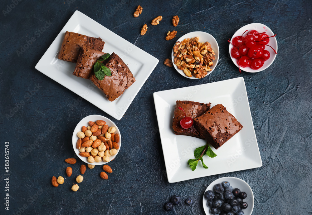 Plates with pieces of tasty chocolate brownie on black background