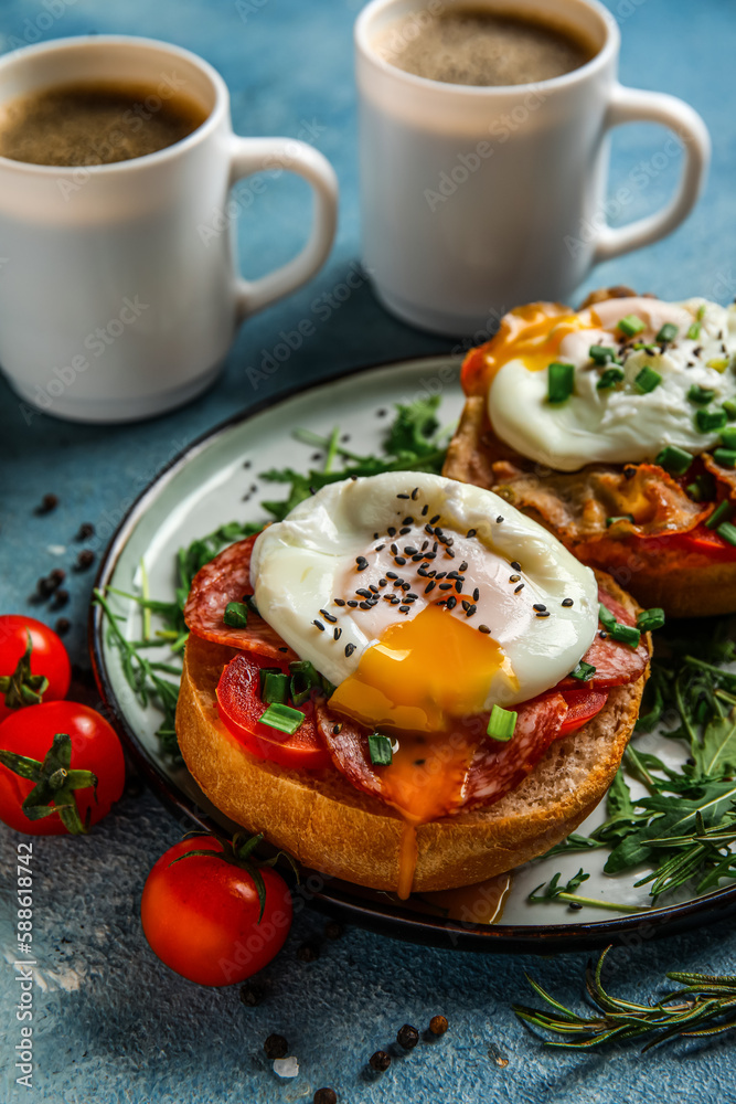 Plate with tasty eggs Benedict on blue background